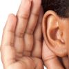Ohr mit dahinter gehaltener Hand was zuhören suggeriert 